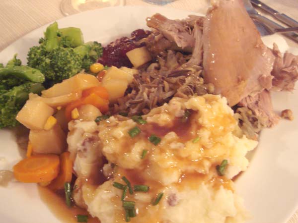 Clockwise from top, cranberry sauce, stuffing, turkey, mashed potatoes, glazed root vegetables and broccoli.